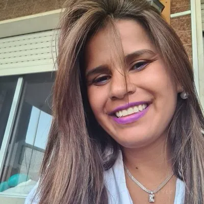 Juli sonriendo con melena castaña lisa y labios lilas