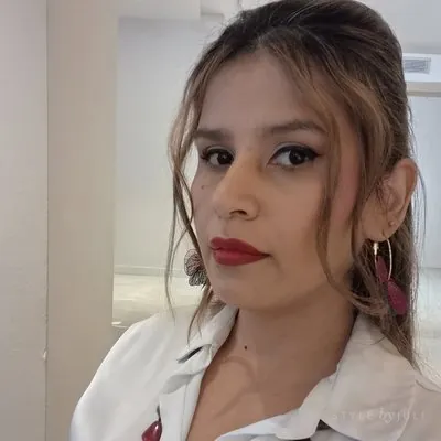 Juli con semirrecogido, camisa blanca y labios rojos